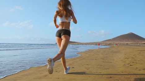 Sportlerin-Silhouette,-Die-Am-Strand-Läuft-Und-Wellen-Sprintet,-Die-Am-Morgen-Im-Hintergrund-In-Zeitlupe-Am-Meer-Abstürzen